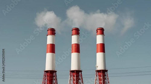 Industrial Smokestacks Emitting Smoke Against Blue Sky
