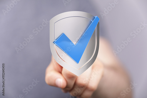 Hand holding a silver shiel...