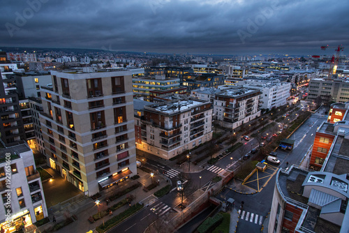 Картината върху платно The town of Massy with its residential and industrial buildings lit up at night