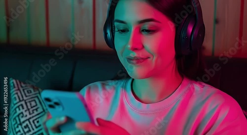 Woman with headphones using smartphone illuminated by vibrant neon colors and cool lighting set against a wooden wall background with textures