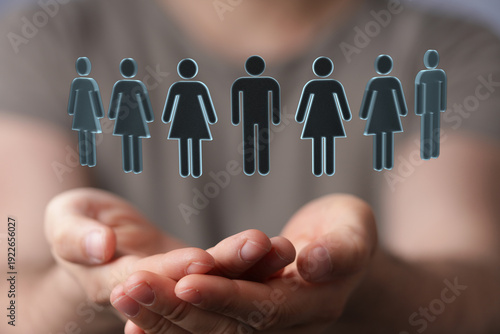 Bilde på lerret Concept image of a hand holding human figures