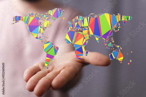 Photos Abstract low poly world map on a hand, representing global connectivity, diversity and communication