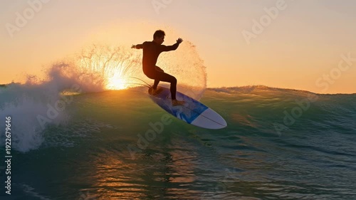 surfer riding a wave during a beautiful sunset over the ocean