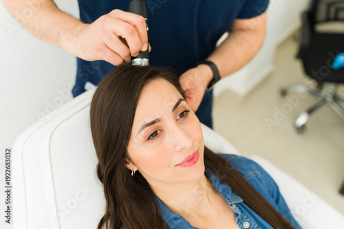 Billede på lærred Woman getting scalp analysis with hair microscope at trichology clinic investiga