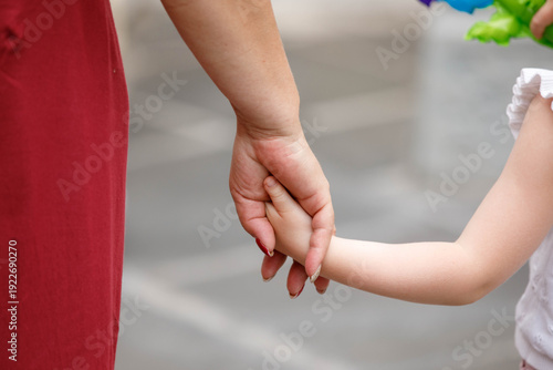 Mother holding her young daughter's hand while sightseeing, protecting and caring, mother and child skin, close up, at Wat Arun.