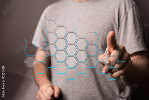 A person pointing to a digital hexagonal network, representing modern technology and data.