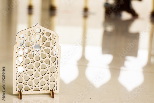 Islamic geometric ornament on mosque floor with blurred arch background. Elegant Ramadan and Eid Mubarak religious decoration concept