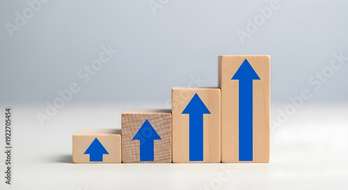 Business growth strategy increasing upward trend indicated by wooden blocks with blue arrow graphics