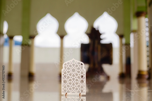 Islamic geometric ornament on mosque floor with blurred arch background. Elegant Ramadan and Eid Mubarak religious decoration concept