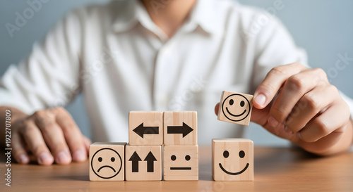 Person placing smiley face wooden block to improve customer satisfaction feedback rating effectively always