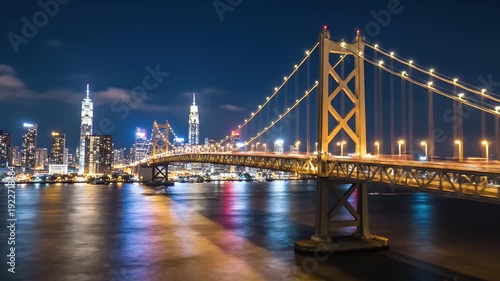 Night Cityscape with Bridge - This video captures a stunning nighttime cityscape featuring a large bridge illuminated with golden lights crossing over a waterway.