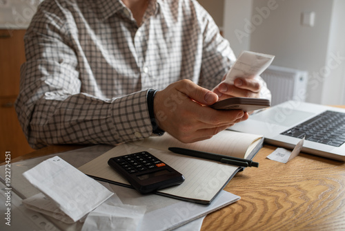 Schilderij op canvas Man at home kitchen calculate and planning family financial budget