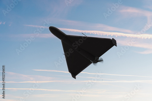 Bilde på lerret Military drone in flight with atmospheric vapor trails around.