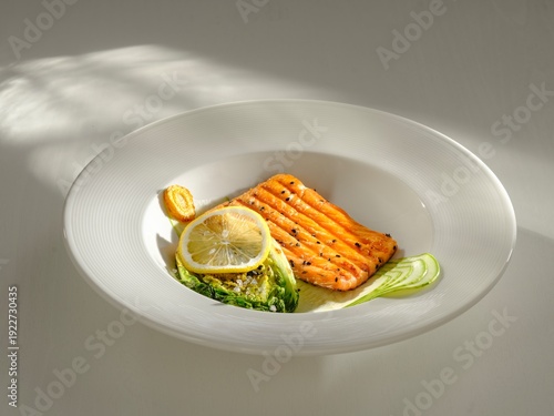Grilled salmon fillet showcases vibrant colors, garnished with lemon slices and green vegetables, elegantly arranged on a white plate, perfect for fine dining moments