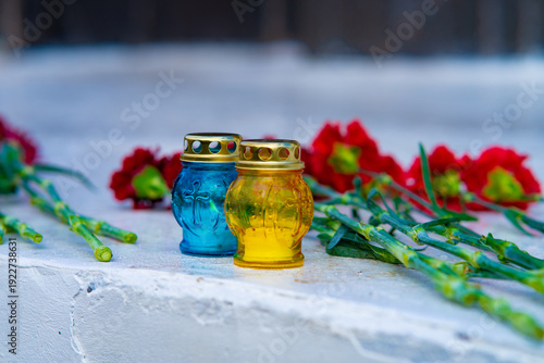 Memorial Blue and Yellow Candles with Red Carnations for Remembrance Day in Ukraine