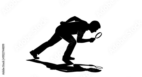 Silhouette of a man bending down to pick up tennis ball with racket.