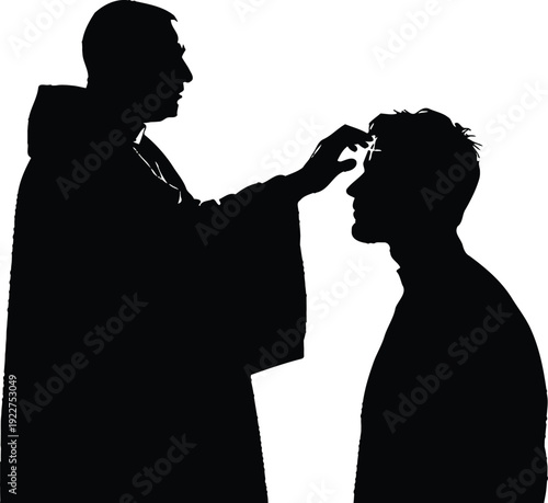 A priest blessing a man in silhouette during a sacred religious ceremony