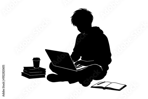Silhouette of teen working on laptop with books and coffee.