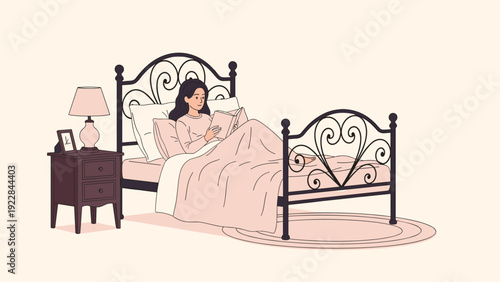 Relaxed young woman sitting comfortably in her bed at night while reading a book by the light of a bedside lamp in a cozy bedroom.