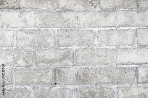 Gray concrete block wall texture background. Rough cement surface with joints and weathered stains. Industrial masonry pattern for construction, architecture, renovation and urban exterior design.