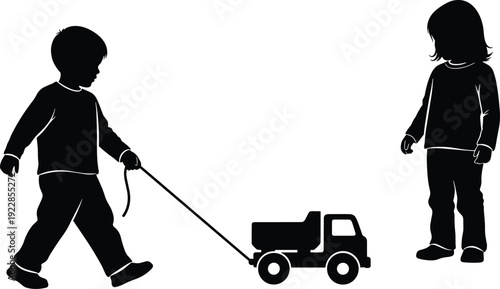Black silhouette of a little boy pulling a toy truck on a string toward a young girl standing and playing together.