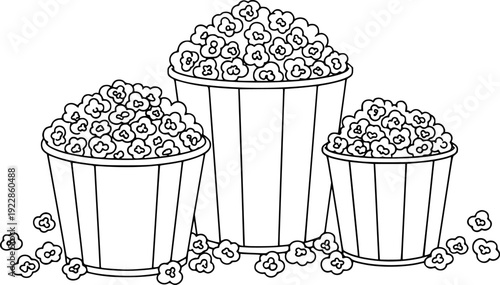 Striped buckets overflowing with popcorn kernels and scattered popcorn pieces snack