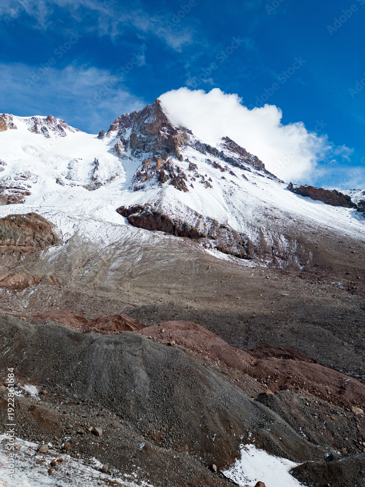 Obraz premium Aerial view of Mount Kazbek with exposed rocky terrain and glacial formations in the Greater Caucasus, Georgia