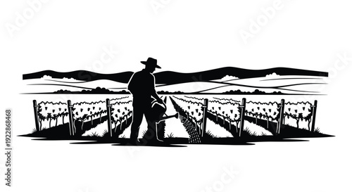 A silhouetted vineyard worker tending to grapevines in a landscape