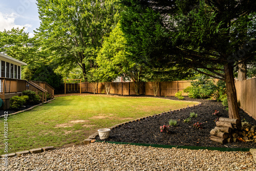 Bilde på lerret Landscaped suburban backyard with green lawn and wooden fence