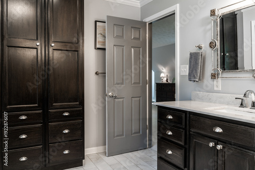 Fotografia Modern bathroom interior with dark wood cabinets and gray door