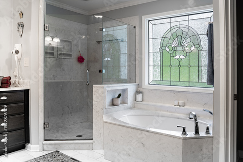 Foto Modern master bathroom with white marble tub and stained glass window