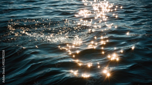 Sunlight glimmers on gentle ocean waves, creating sparkling reflections on the deep blue water surface.