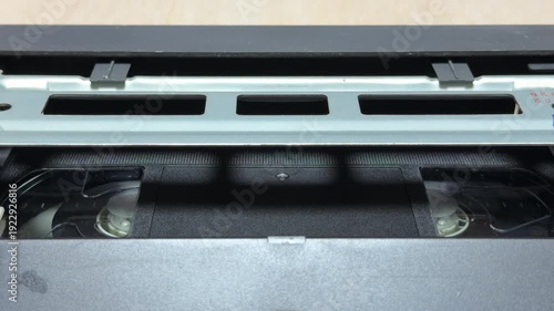 The VCR internal mechanism pulls the VHS tape into position for playback. This action creates a sequence of heavy mechanical clicks followed by a steady motorized whirring sound.