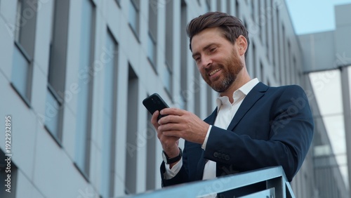 Tableau sur toile Stylish adult Caucasian business man holding mobile phone in city smiling mature
