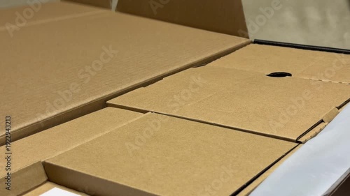 Several small corrugated boxes sit nested inside a larger shipping container. The brown cardboard flaps are folded to create a protective, organized layout for transporting items safely.