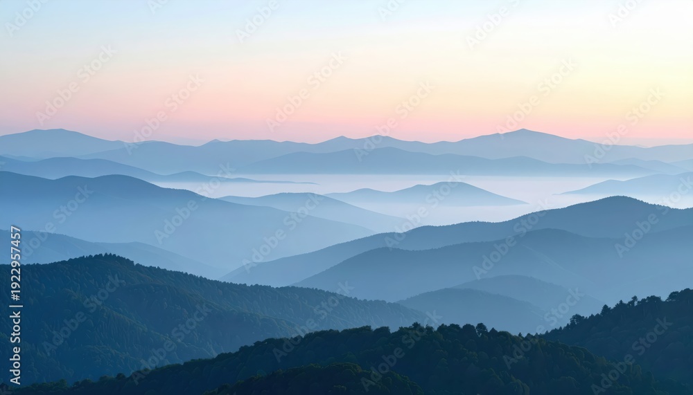 Fototapeta premium Misty mountain ranges at sunrise with soft pink and blue hues and dense forest in foreground