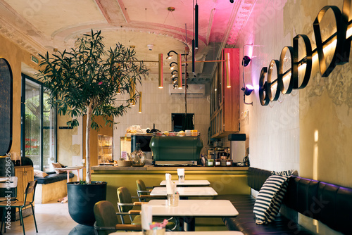 Stylish, modern, cafe, interior, with, cozy, seating, warm, lighting, and, greenery, accents