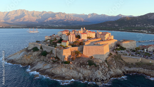 Aerial view of calvi citadel at sunrise with serene waters. Fortress with marina. Corsica. France