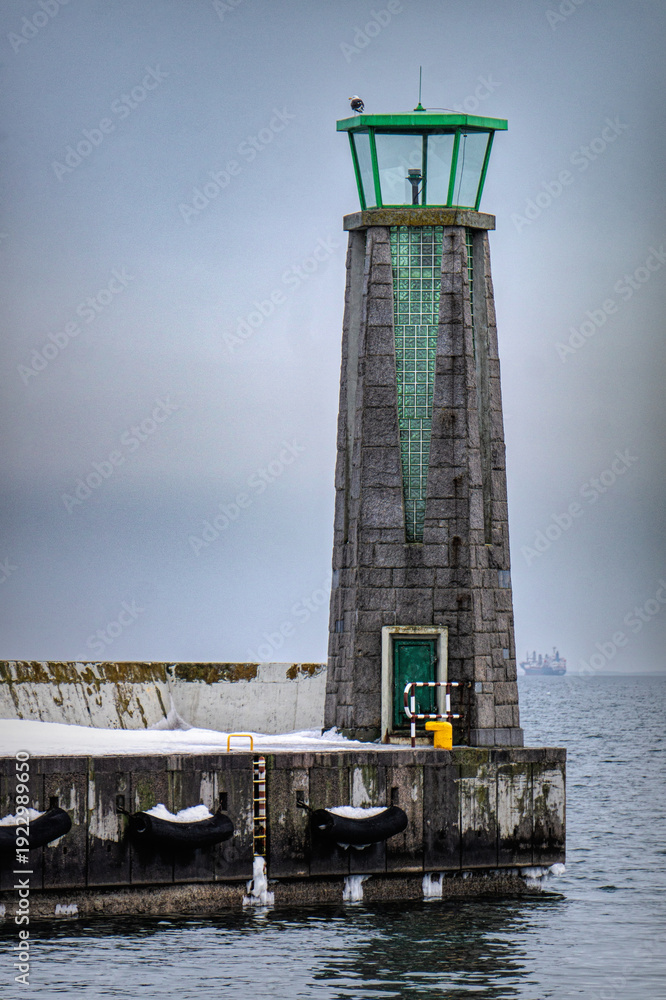 Fototapeta premium Cold winter weather in Europe. Lighthouse and pier in Gdynia 