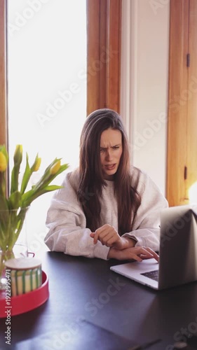 Frustrated young woman looking at laptop screen with annoyance and confusion female freelancer expressing irritation and disbelief while working at home office, negative emotions and technology stress