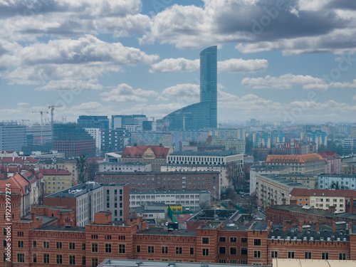 Картината върху платно Wroclaw, Poland cityscape shows Sky Tower rising over Gothic and early 20th century facades, modern offices, urban streets, cranes, and broken clouds in daylight
