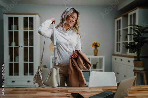 Tableau sur toile Professional woman getting ready for work, taking her handbag and jacket, prepar