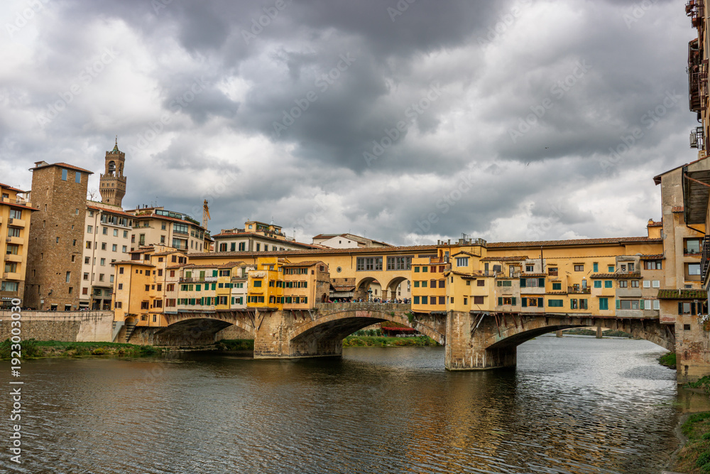 Fototapeta premium Famous historic Ponte Vecchio bridge and old buildings along the Arno river in Florence Italy