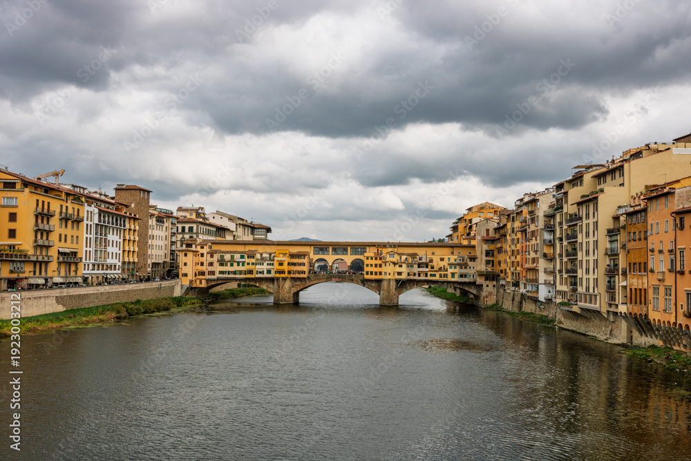 Fototapeta premium Famous historic Ponte Vecchio bridge and old buildings along the Arno river in Florence Italy