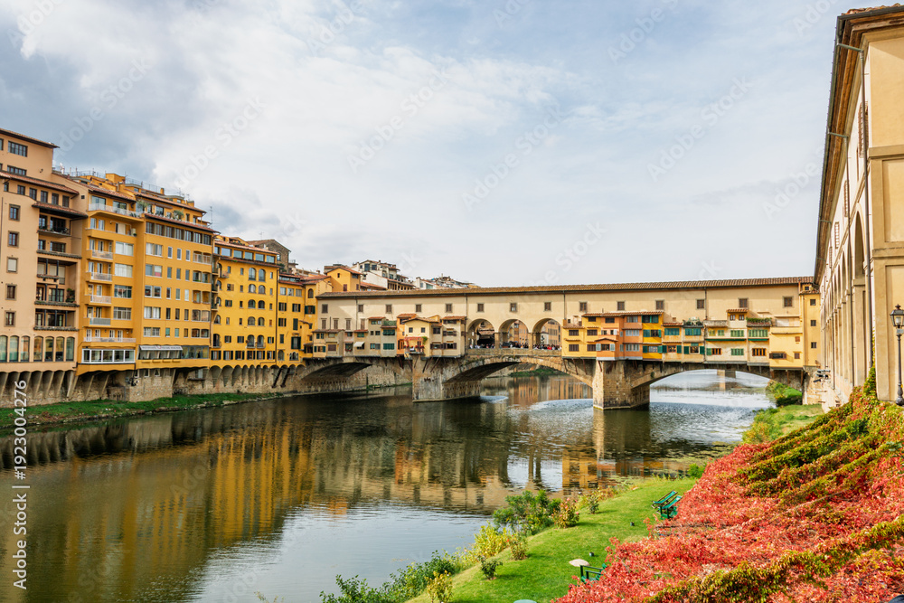 Fototapeta premium Famous historic Ponte Vecchio bridge and old buildings along the Arno river in Florence Italy
