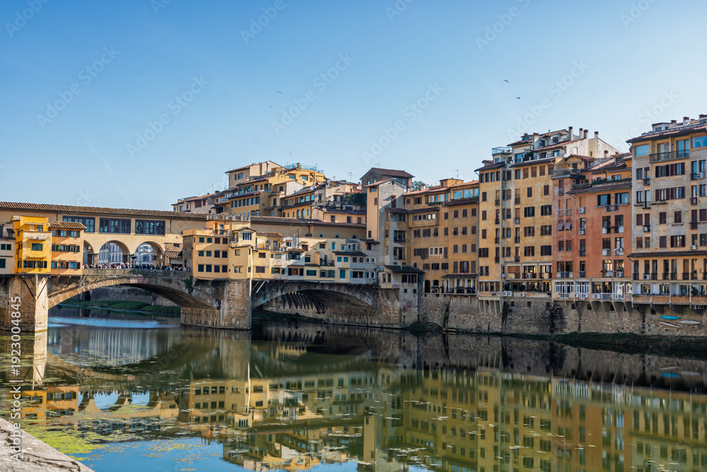 Obraz premium Famous historic Ponte Vecchio bridge and old buildings along the Arno river in Florence Italy