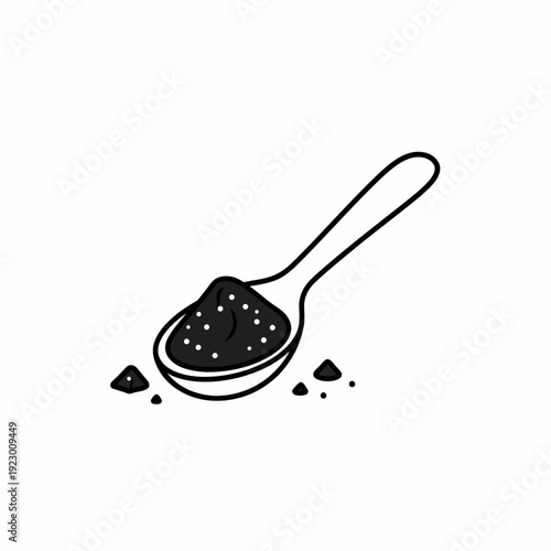 A spoonful of black powder resting on the spoon