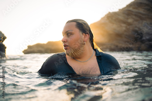 Person Enjoying Sunset Swim in Rocky Coastal Waters