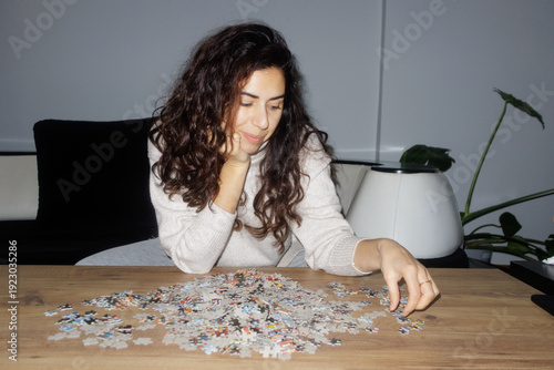 A young woman is putting together a puzzle