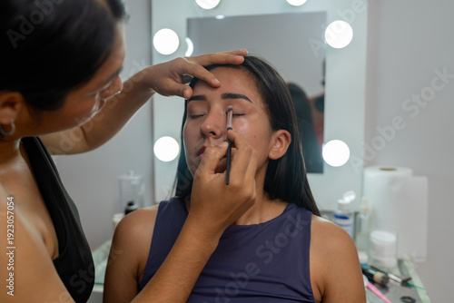 Bild auf Leinwand Makeup artist applying eyeshadow to young latina woman